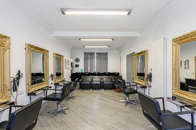 large salon roon with chairs either side and mirrors and sinks at the far end hd hair and beauty 